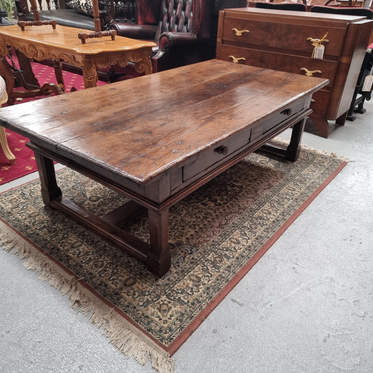 Impressive large size rustic French Oak coffee table with two drawers on a stretcher base. In good original detailed condition and sourced from France.