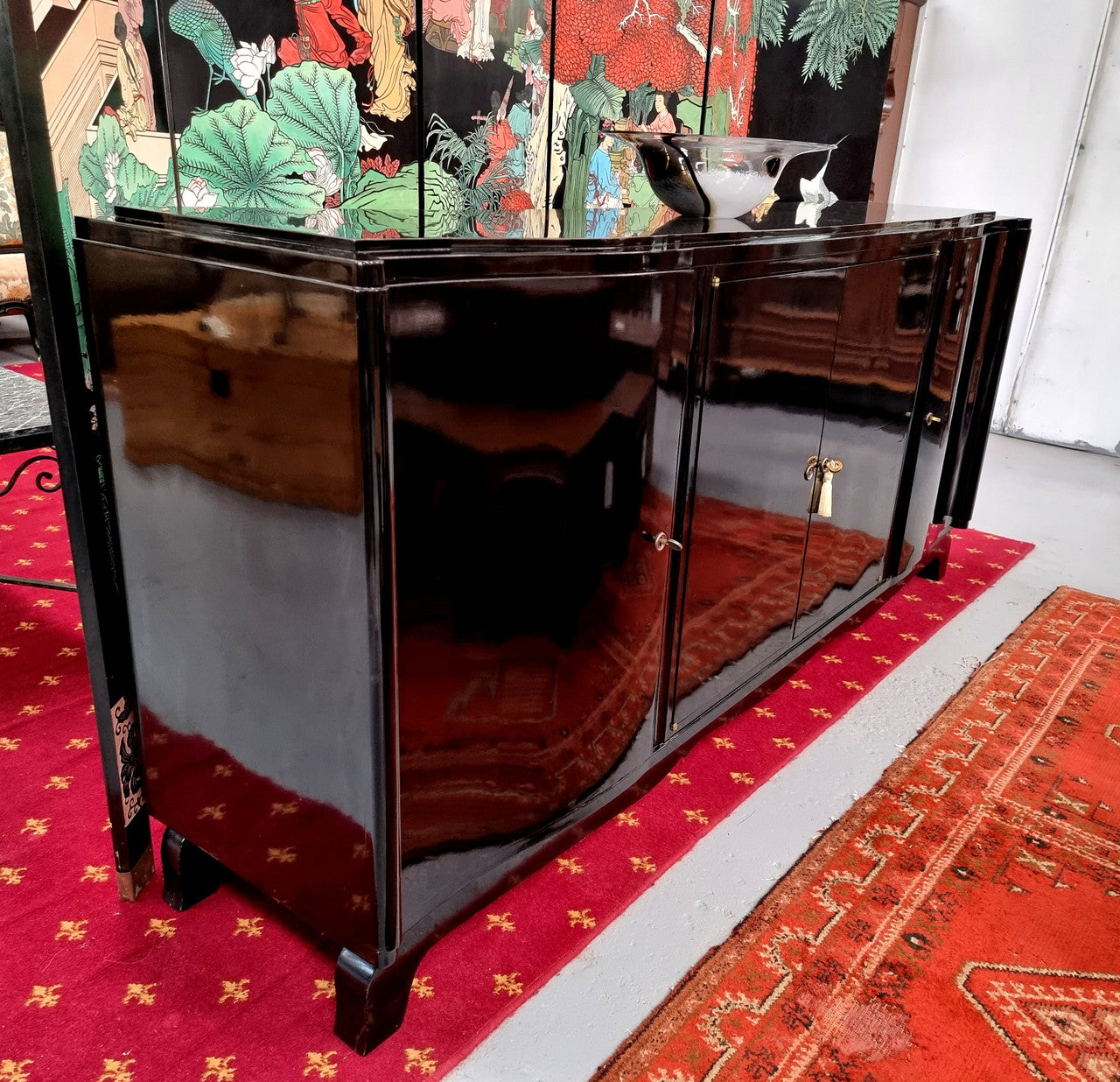 French Art Deco sideboard with a custom black lacquer finish. Beautiful serpent shaped front with four cupboards with working locks and includes to working keys. It is in original condition.