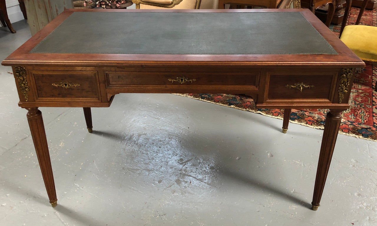 Lovely French Mahogany Louis XVI style leather top desk. With beautiful ormolu details and three drawers. There are also two slides on either side with tooled leather tops and in good original detailed condition.