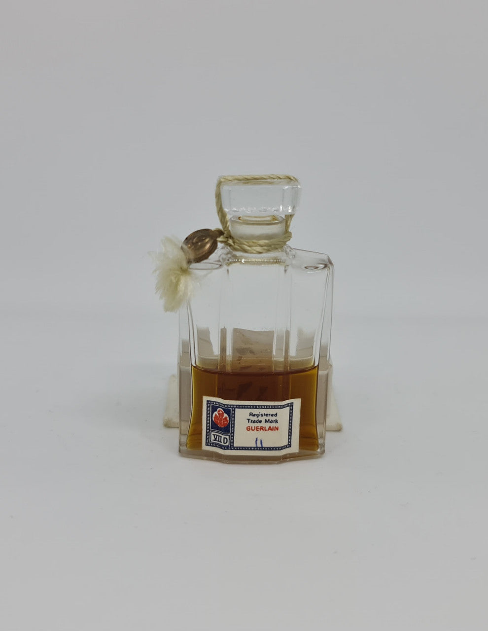 Vintage "Jicky" perfume bottle in great original condition with white base that it sits in.