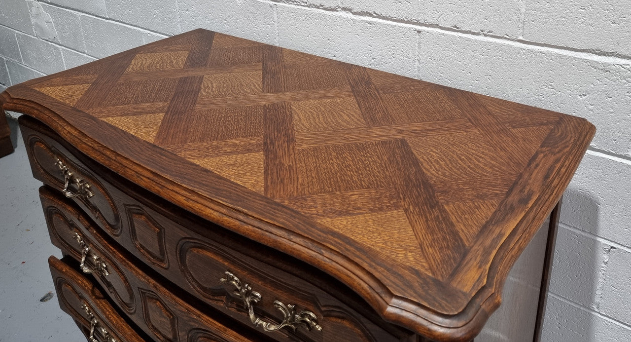 Lovely French nicely carved chest of 3 drawers with a parquetry top, with decorative handles and lovely carving. In good detailed condition.