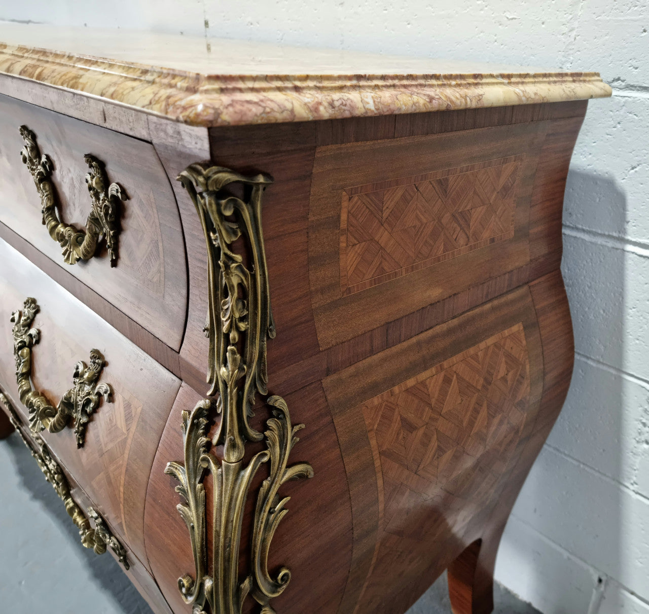 A beautifully inlaid parquetry three drawer commode with a lovely marble top, and decorative ormolu mounts. In good original detailed condition. Circa 1930