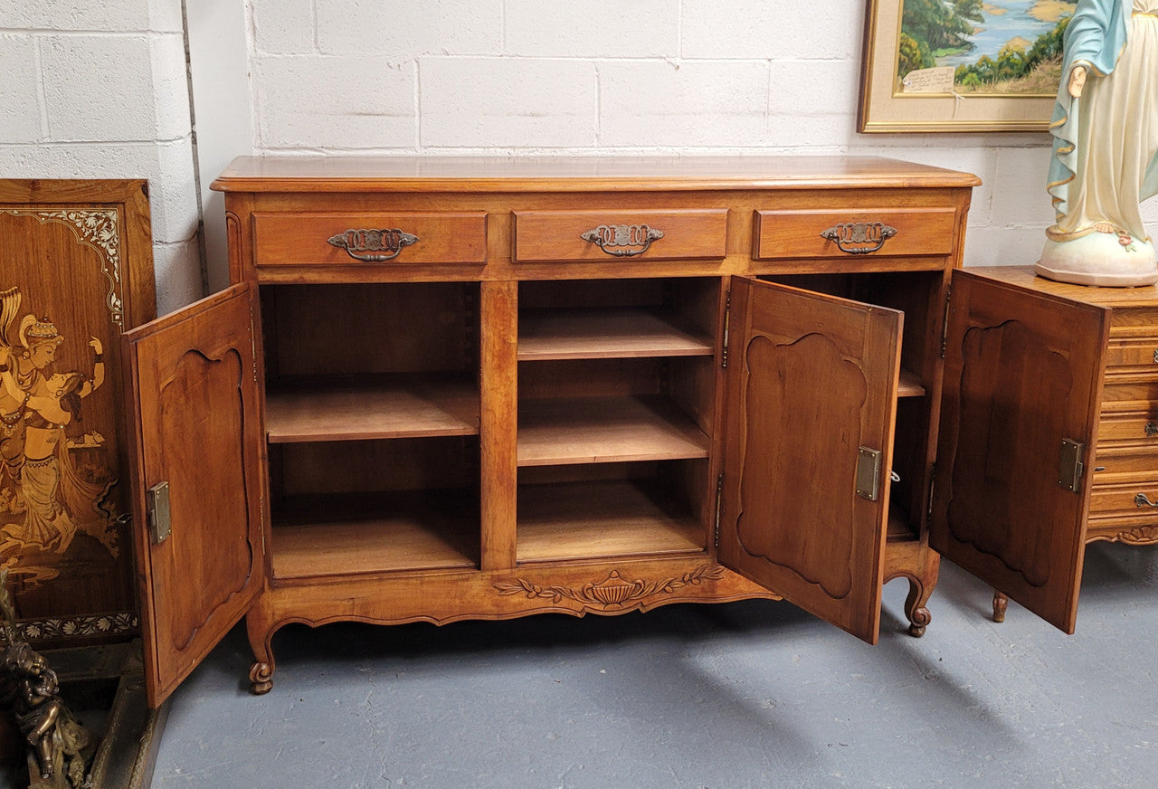 Beautiful French three door three drawer Louis XV style Cherrywood sideboard. It has a total of four adjustable shelves and comes with three keys. It has been sourced from France and is in good original detailed condition.