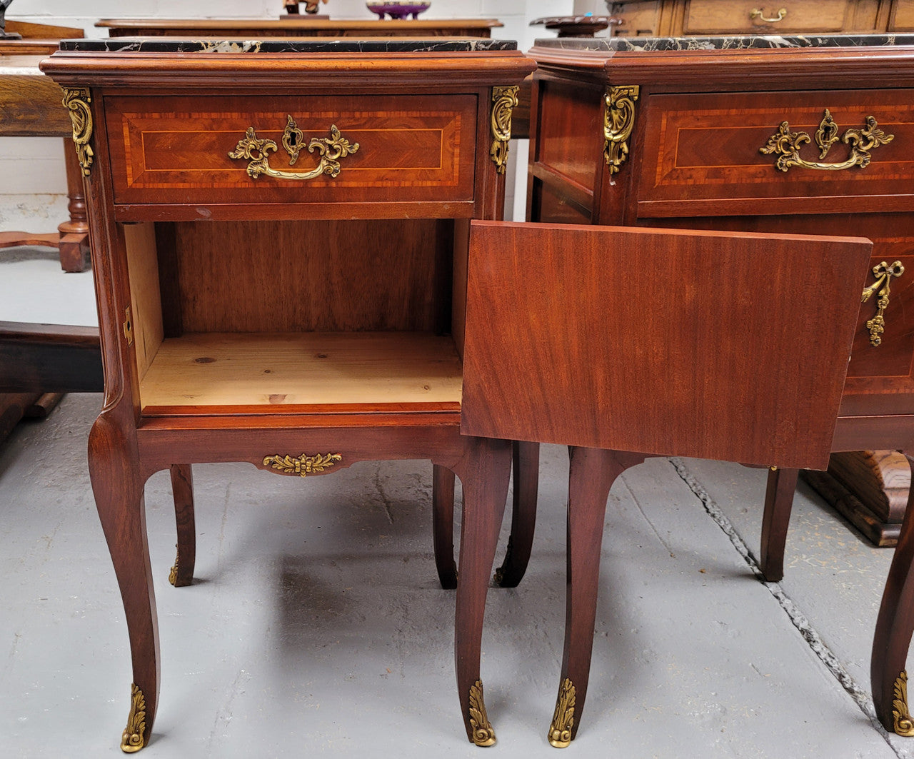 Appealing Louis XV style high quality bedside cabinets with black Portoro marble top and bronze mounts. They have been sourced from France and are in good original condition.