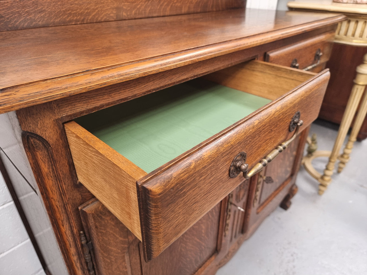 French Louis XV style Oak two door, two drawer sideboard. It is of pleasing narrow proportions and has one interior shelf. It has been sourced from France and it is in good original detailed condition.
