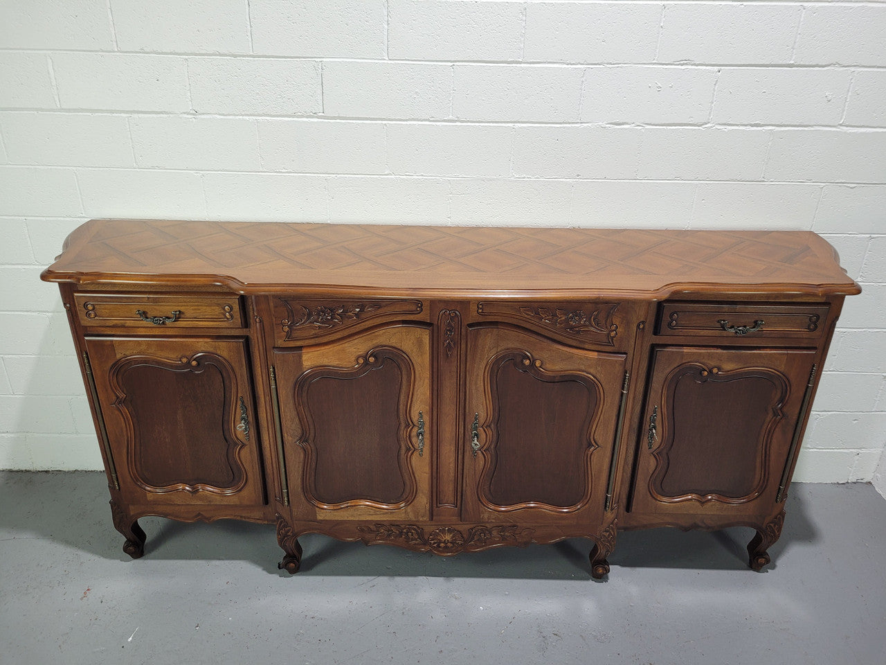 Walnut Louis XV style parquetry top four door sideboard with beautiful carving. Plenty of storage space and it is in good original detailed condition.