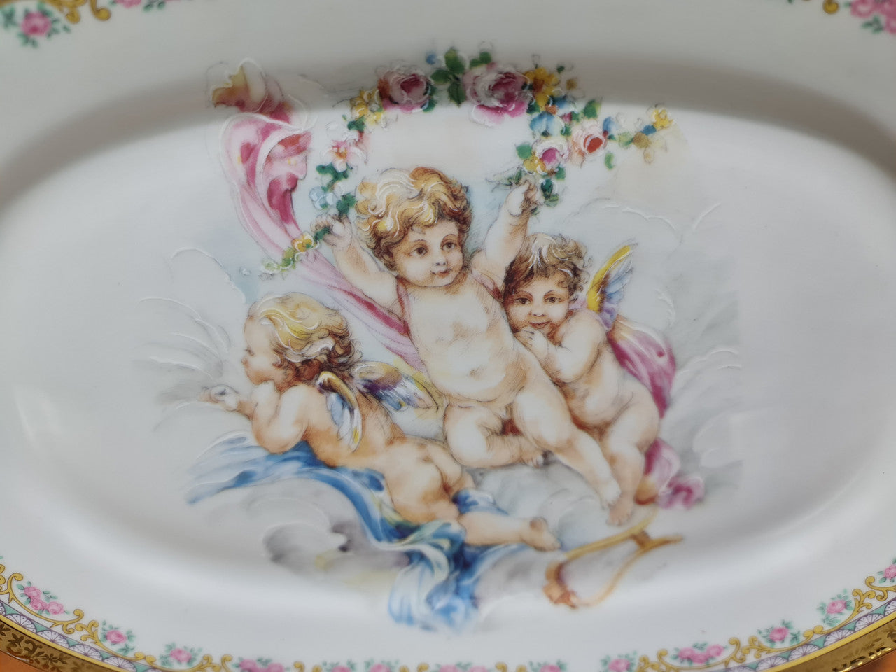 Beautiful T. Limoges porcelain decorative oval plate depicting 3 cherubs with gold edging. In good original condition.