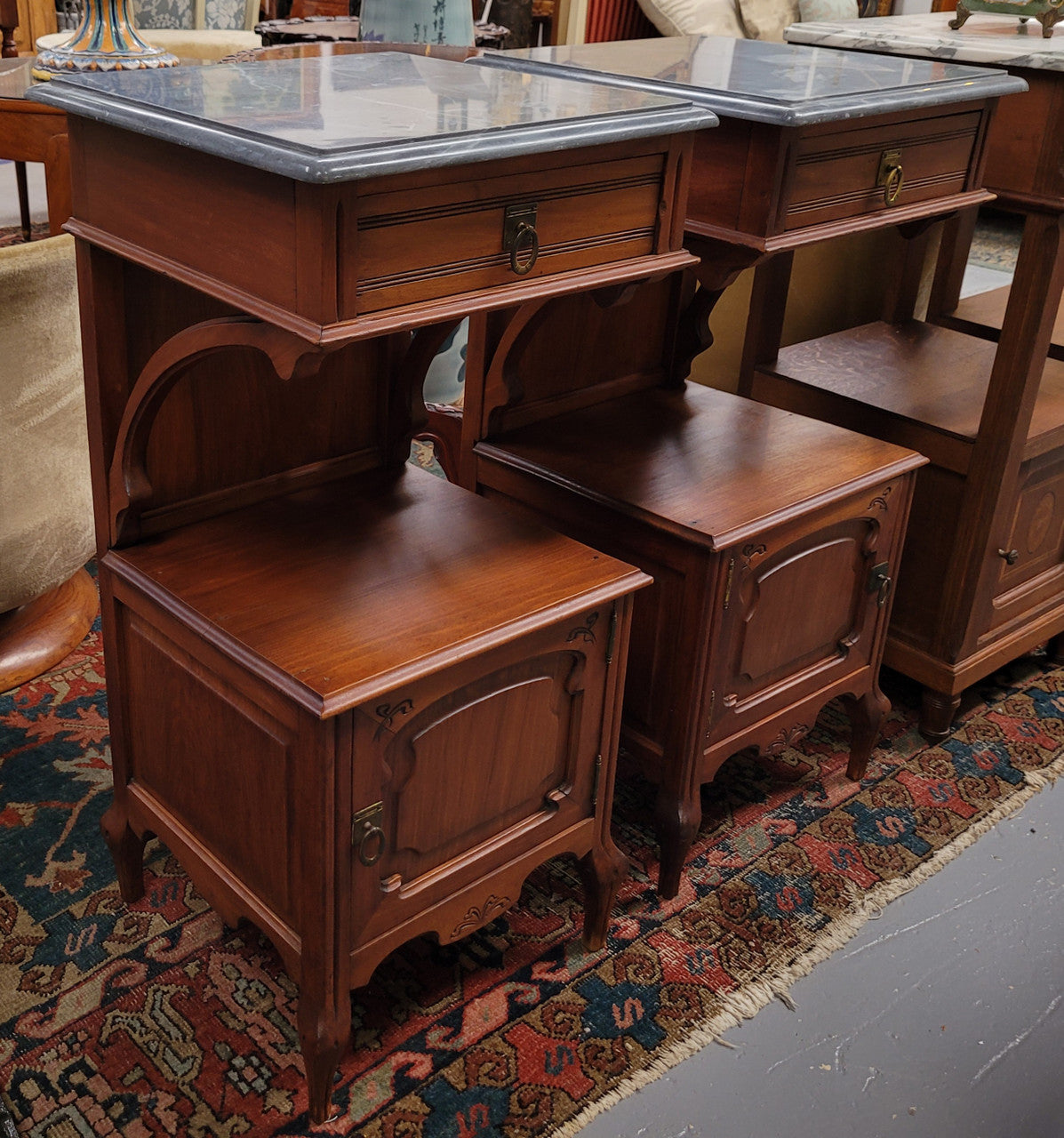 Pair of unusual transitional fruit wood marble top bedside cabinets. They have been sourced from France and are in good original detailed condition.