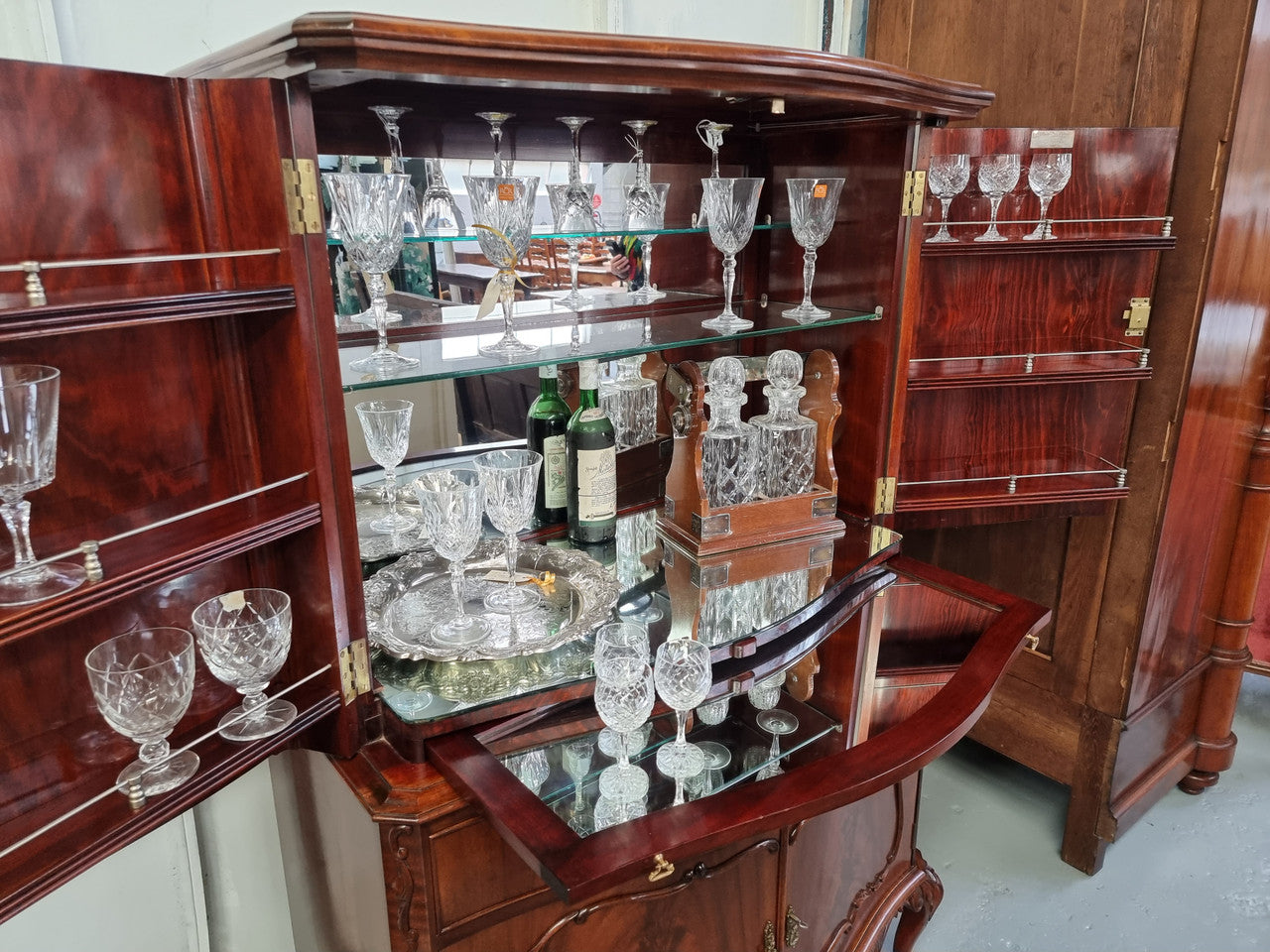 1950’s Chippendale Style Flame Mahogany Four door Bar. The top section has glass shelves and a mirrored pull out tray for storing glasses, decanters & serving etc. It also has a silver presentation plaque to the Mayor of Hawthorn 1958. The bottom section is for storage bottles etc. A stunning and practical piece.