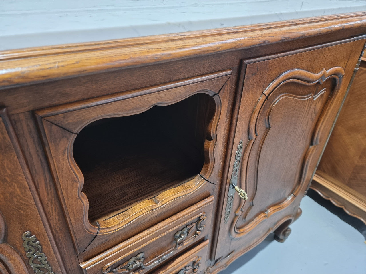 Lovely Louis XV style French Oak carved sideboard with two drawers and two cupboards for all your storage needs. It has a nice coloured marble top and in good original detailed condition.