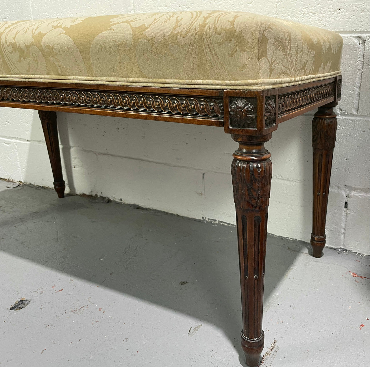 Nicely carved French Louis XVI style Walnut upholstered stool. The stool is in good condition and the frabic is in good used condition, please view photos as they help form part of the description.
