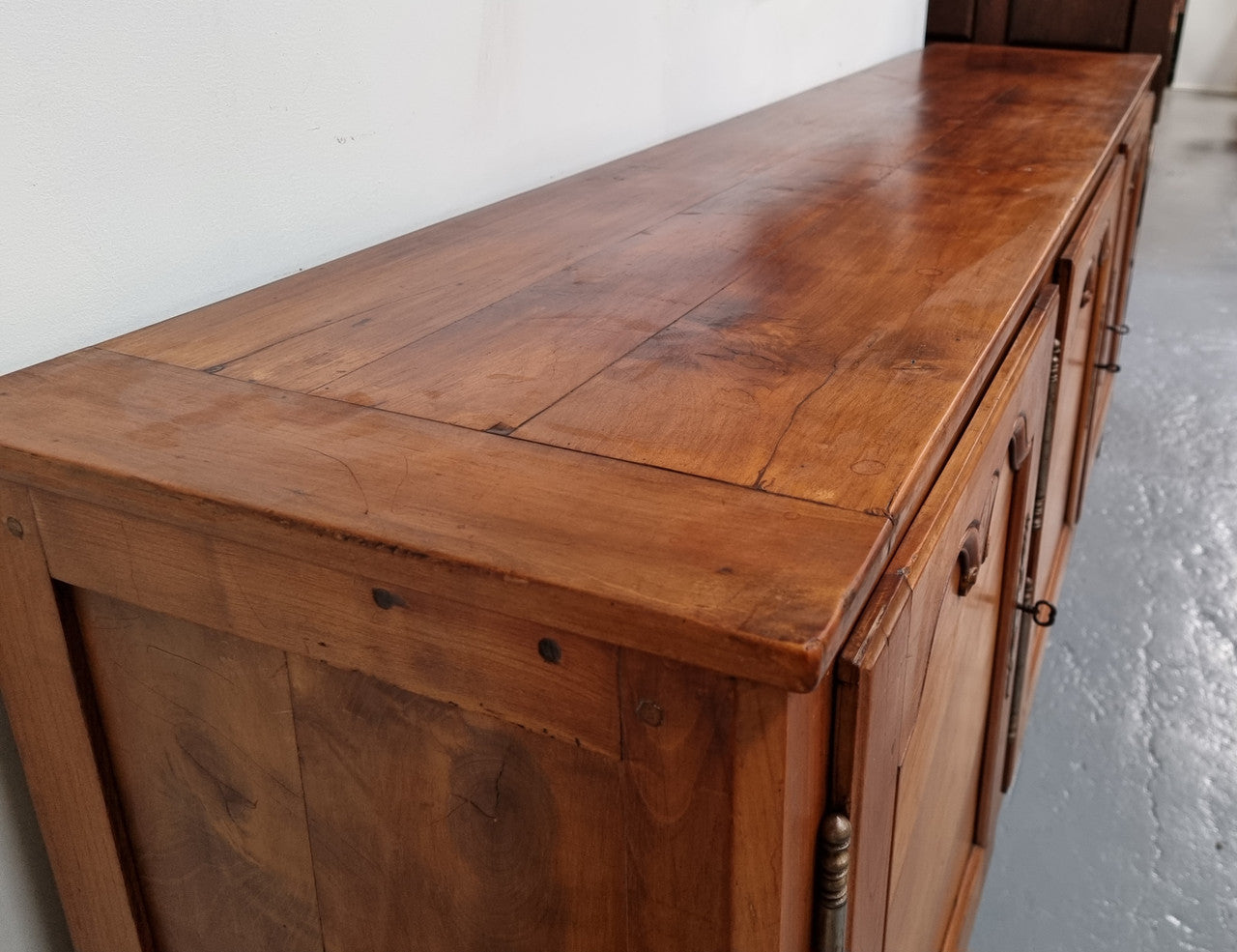 Early 19th Century Louis XV style Fruitwood three door sideboard. It has three hidden internal drawers and one of them has green valet and small sections for cutlery. It is in good restored condition.