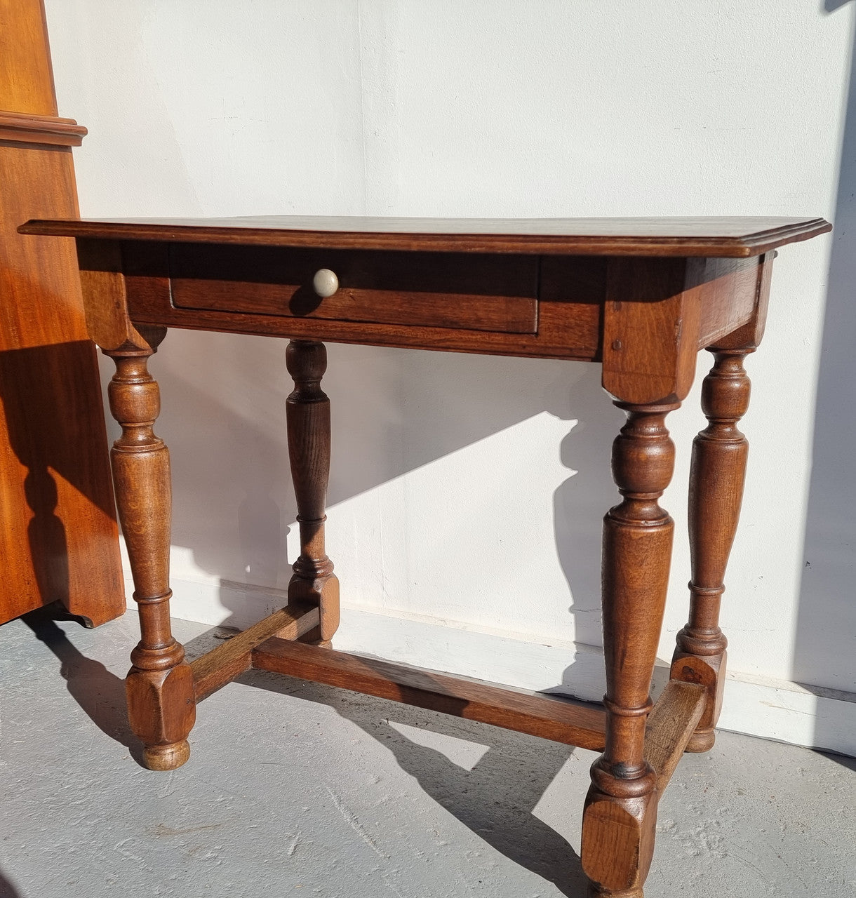 Rustic French Oak side table or desk with single drawer and turned legs. In good original detailed condition.