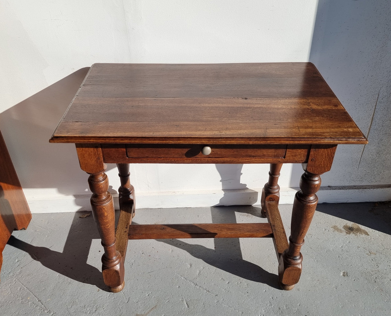 Rustic French Oak side table or desk with single drawer and turned legs. In good original detailed condition.