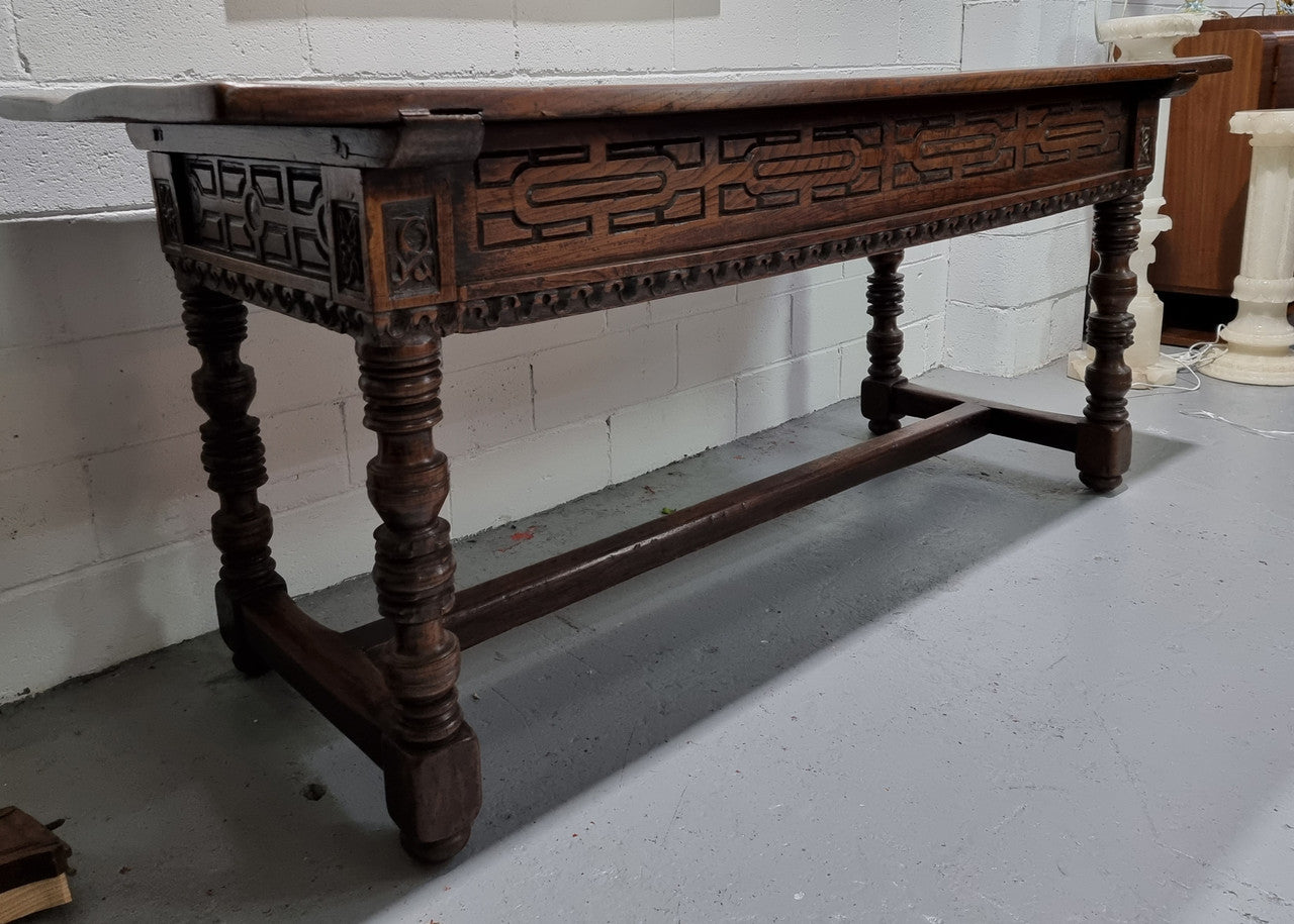 Rare and Charming 17th Century Spanish Walnut serving / side table. It has an incredible one piece walnut top with amazing character and colour. The base displays the original patina aswell as three drawers with carving and remnants of original locks. Superbly turned legs terminating on a stretcher base. Could be used as a large entrance console table, a side table or in a dining area as a serving table. In good original detailed condition especially considering its age.
