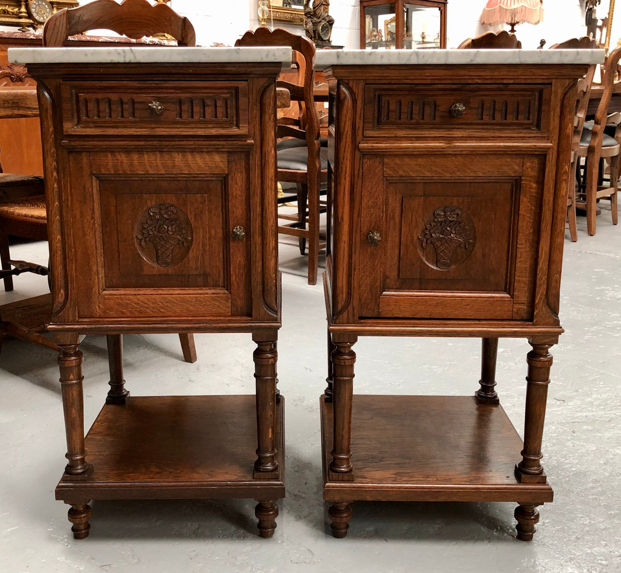 A french oak pair of carved bedside cabinets, with lovely detail and nice coloured marble tops and plenty of storage space. In good condition.