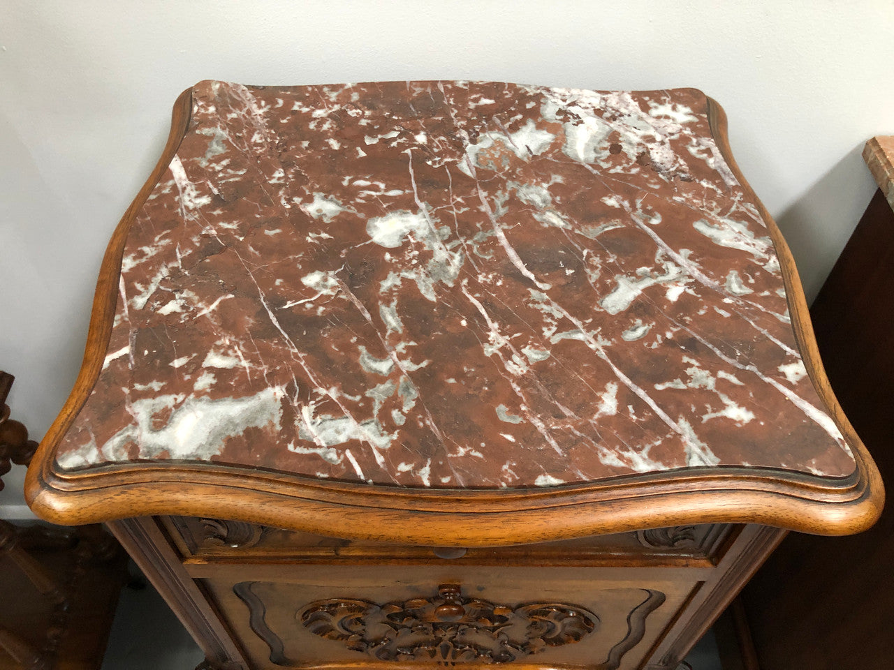 Single French carved bedside with inset marble top. It has beautiful carving and a drawer and cupboard for storage. In very good original detailed condition.