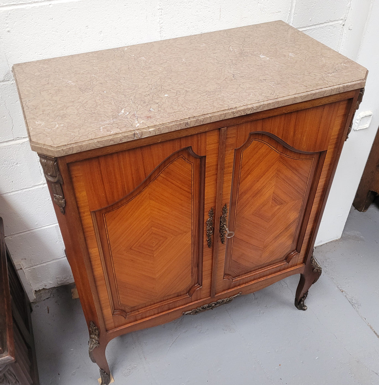 Stunning compact Louis 15th style two door walnut cabinet with ormolu trim and marble top. It is in good original condition.