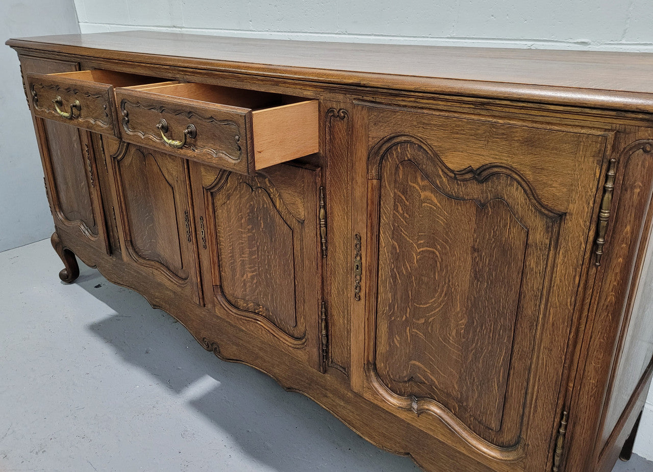 Late 19th Century French carved Oak Louis XV style four drawer sideboard. Plenty of storage space with four cupboards and two drawers. It is in good original detailed condition with all locks functioning with keys.
