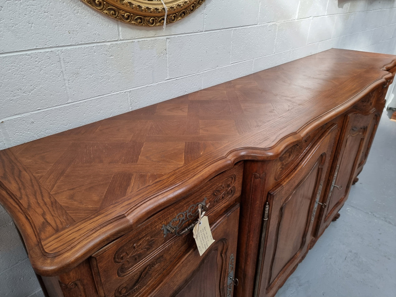Parquetry top French oak Louis XV style sideboard with two draws and four cupboards. In good original detailed condition.