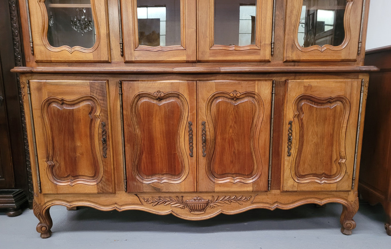 Magnificent French Walnut two-body four door display cabinet. Heaps of storage space with four glass doors at the top with shelves and four solid doors below also with shelving. It has been sourced from France and comes with a key for each door and all are lockable. In good original detailed condition.