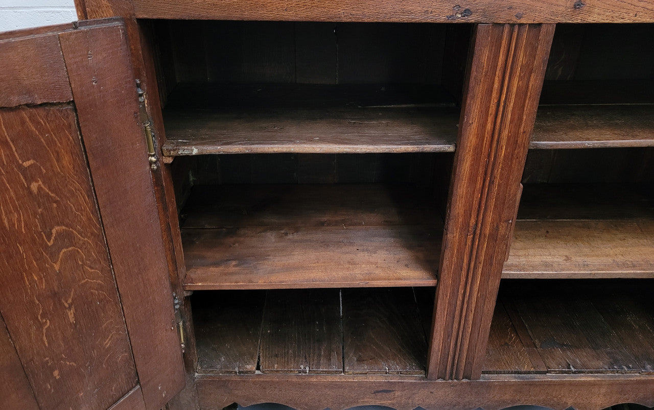 A charming French Oak early 18th Century two door sideboard. Plenty of storage space with two fixed shelves either side. It is in good original detailed condition for its age and comes with a working key and working locks.