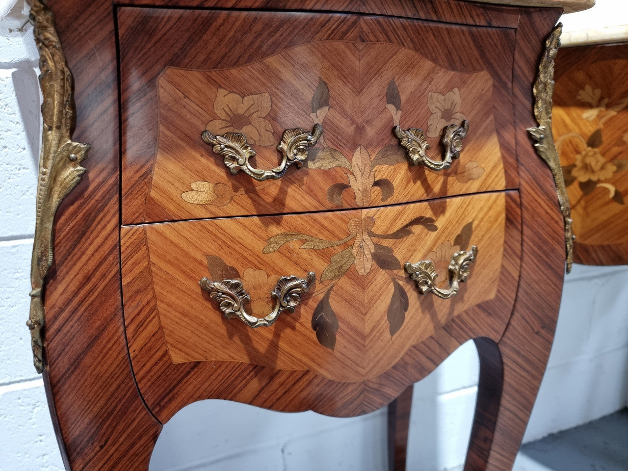 Pair of French bombe shaped commode style marquetry inlaid Kingwood bedside cabinets with marble tops and gilt brass mounts. Circa 1930 in good original detailed condition.