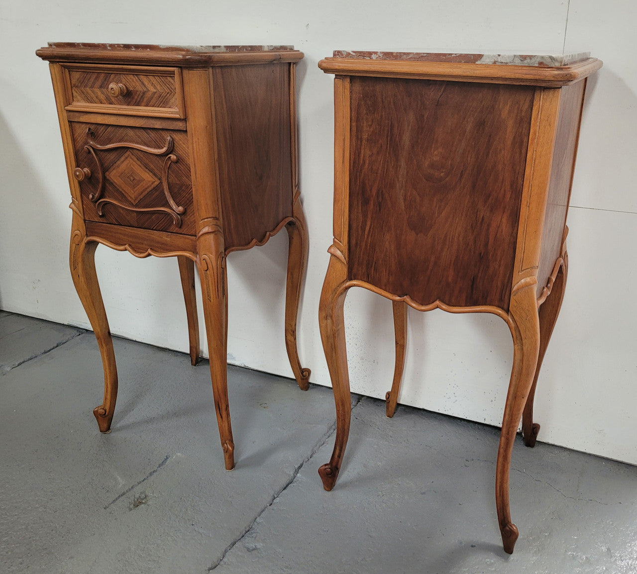 Pair French Walnut Louis XV style Bedside Cabinets with inset rouge carrera marble tops and parquetry inlay. Consisting of one drawer and one cupboard on very elegant legs. Circa: 1900's.