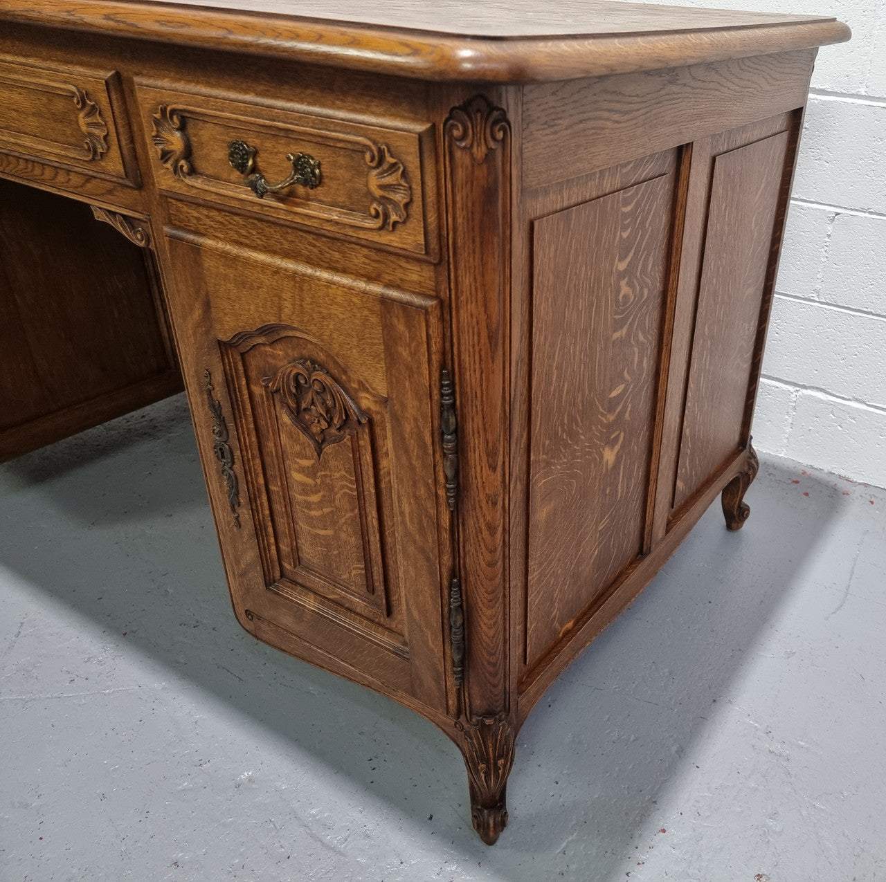 Fabulous French oak carved partners desk with a lovely parquetry top. It has three drawers and two cupboards on one side and two cupboards on the other side with no functioning drawers. It is in good original detailed condition.