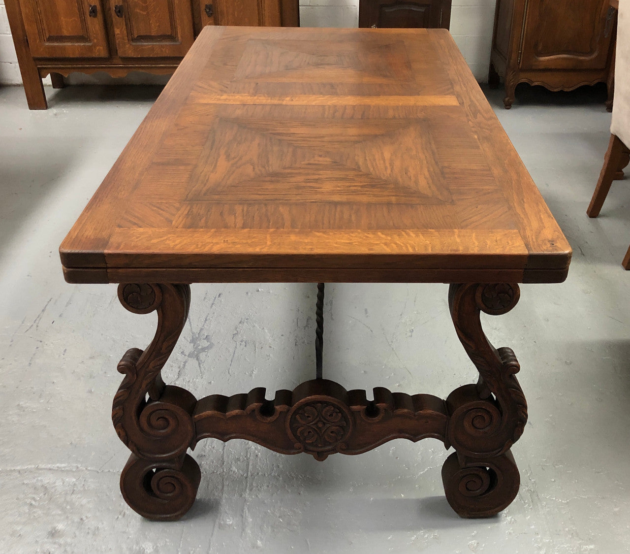 French Oak Renaissance style extension table with a lovely parquetry top and decorative carved and iron base in good original detailed condition.