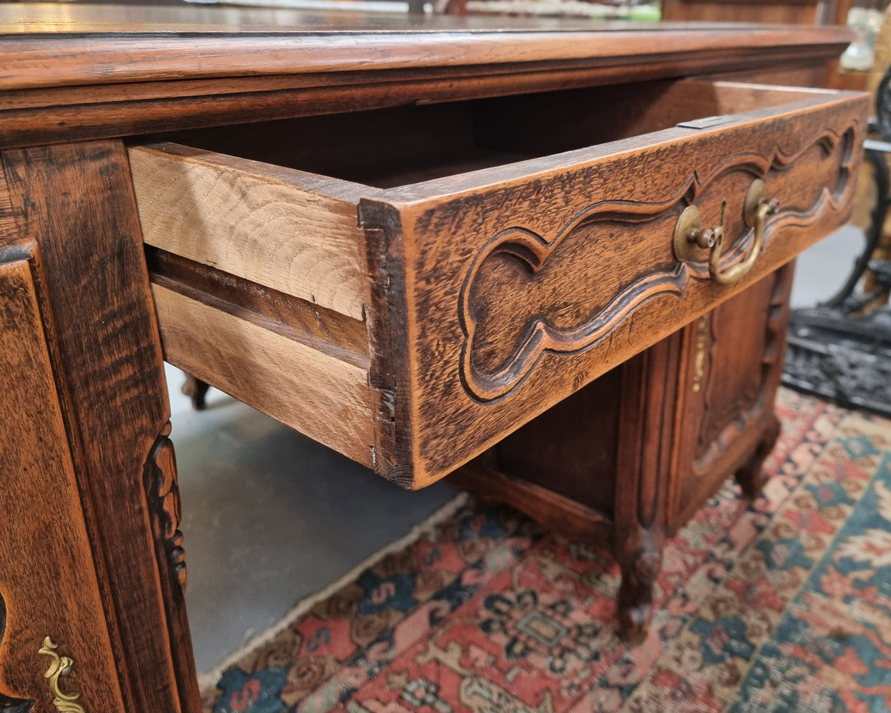 Fabulous Louis XV style French Oak beautifully carved full partners desk with an amazing tooled leather top. Both sides have a functioning drawer in the middle and two cupboards either side. On both sides one cupboard door opens up to four smaller internal drawers. Plenty of storage space and a large top surface to work on. It is in good original detailed condition.