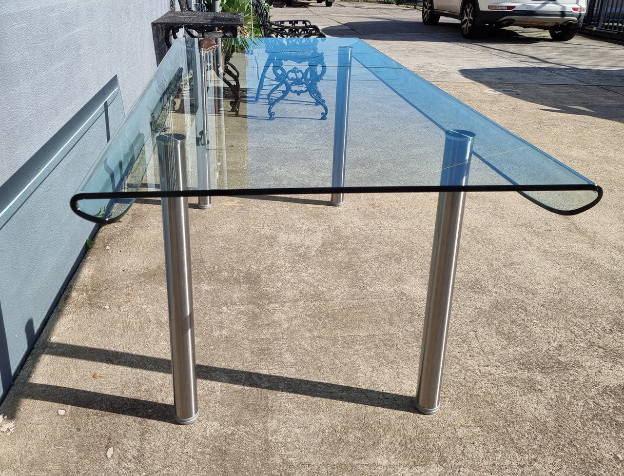 Striking and distinctive Vintage FIAM Italia Designer curved edge glass desk. FIAM was founded in 1973 by Vittorio Livio and has become synonymous with glass culture in Italy and the World. FIAM is still manufacturing today, in collaboration with various Designers, and has won numerous awards and is represented in various international museums. 
Condition: Evidence of use with minor scratches to the surface and a small chip that has been repaired. Overall, in very good condition with one repaired chip to t