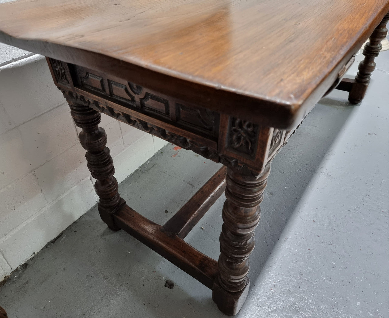 Rare and Charming 17th Century Spanish Walnut serving / side table. It has an incredible one piece walnut top with amazing character and colour. The base displays the original patina aswell as three drawers with carving and remnants of original locks. Superbly turned legs terminating on a stretcher base. Could be used as a large entrance console table, a side table or in a dining area as a serving table. In good original detailed condition especially considering its age.