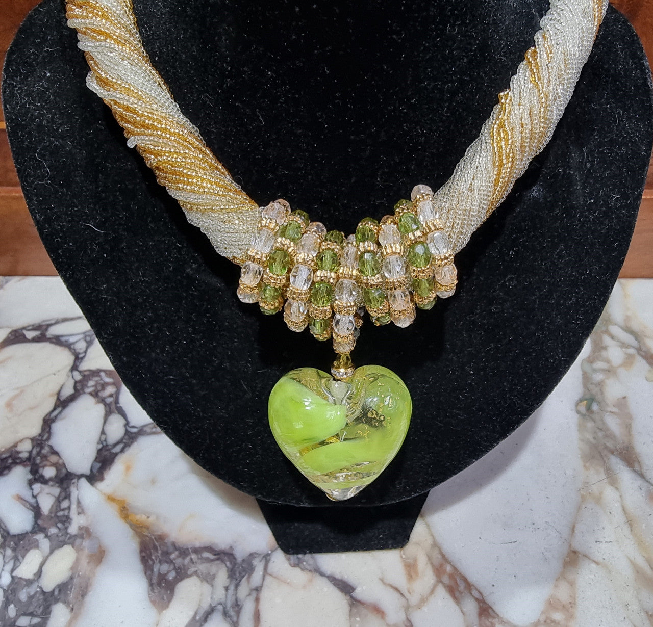 Hand Made Murano glass multi string small glass beads with medium glass beads and a large puff heart in neutral and green shades with gold. In original box.