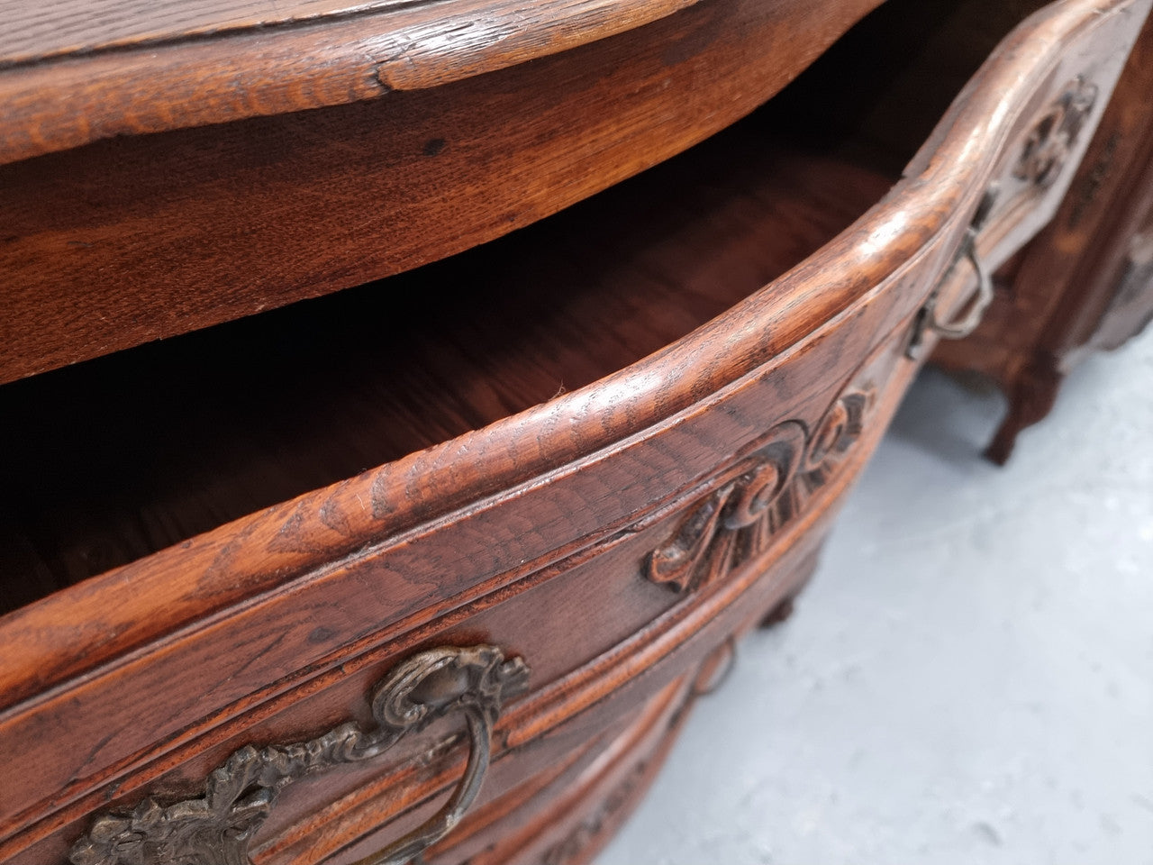 Antique French beautifully carved dark Oak commode with three drawers and ornate handles. It is in good original detailed condition.