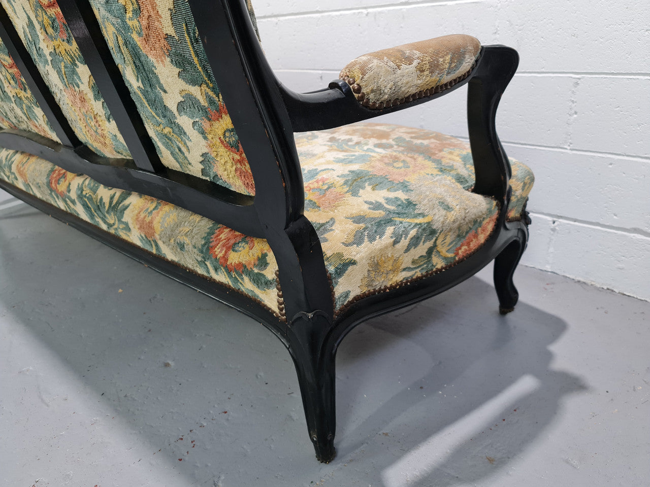 A Substantial Antique 19th Century Louis XV style ebonized serpentine front settee. The fabric is in used condition showing use and could be used as is or reupholster.