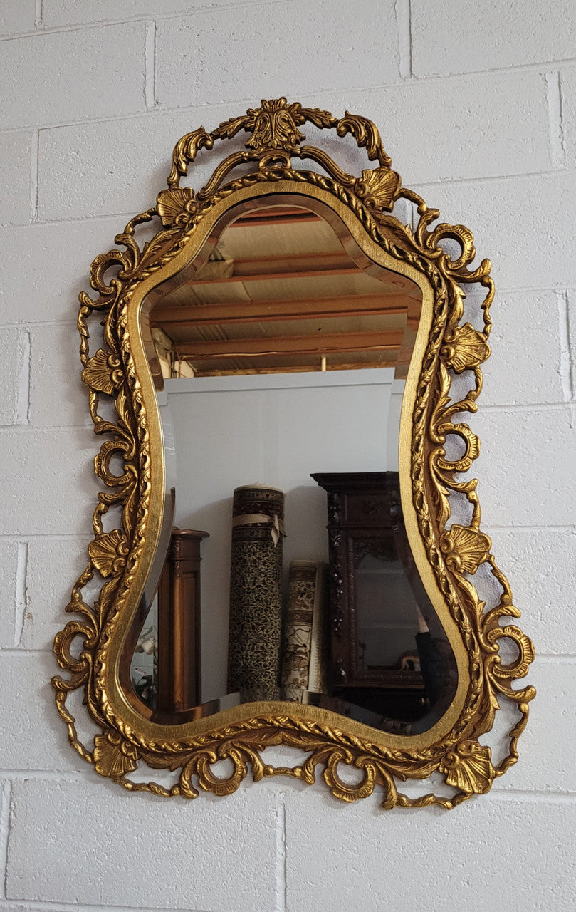Large Vintage Italian carved wood gilt mirror. It has a beautiful bevelled mirror and has been sourced from France. It is in good original condition.