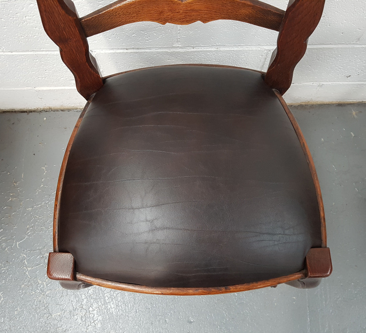 A set of ten French Louis XV style, ladder back oak chairs. With finely carved detail and newly upholstered leather look seat. In great original condition. Chairs are comfortable and sturdy for everyday use.