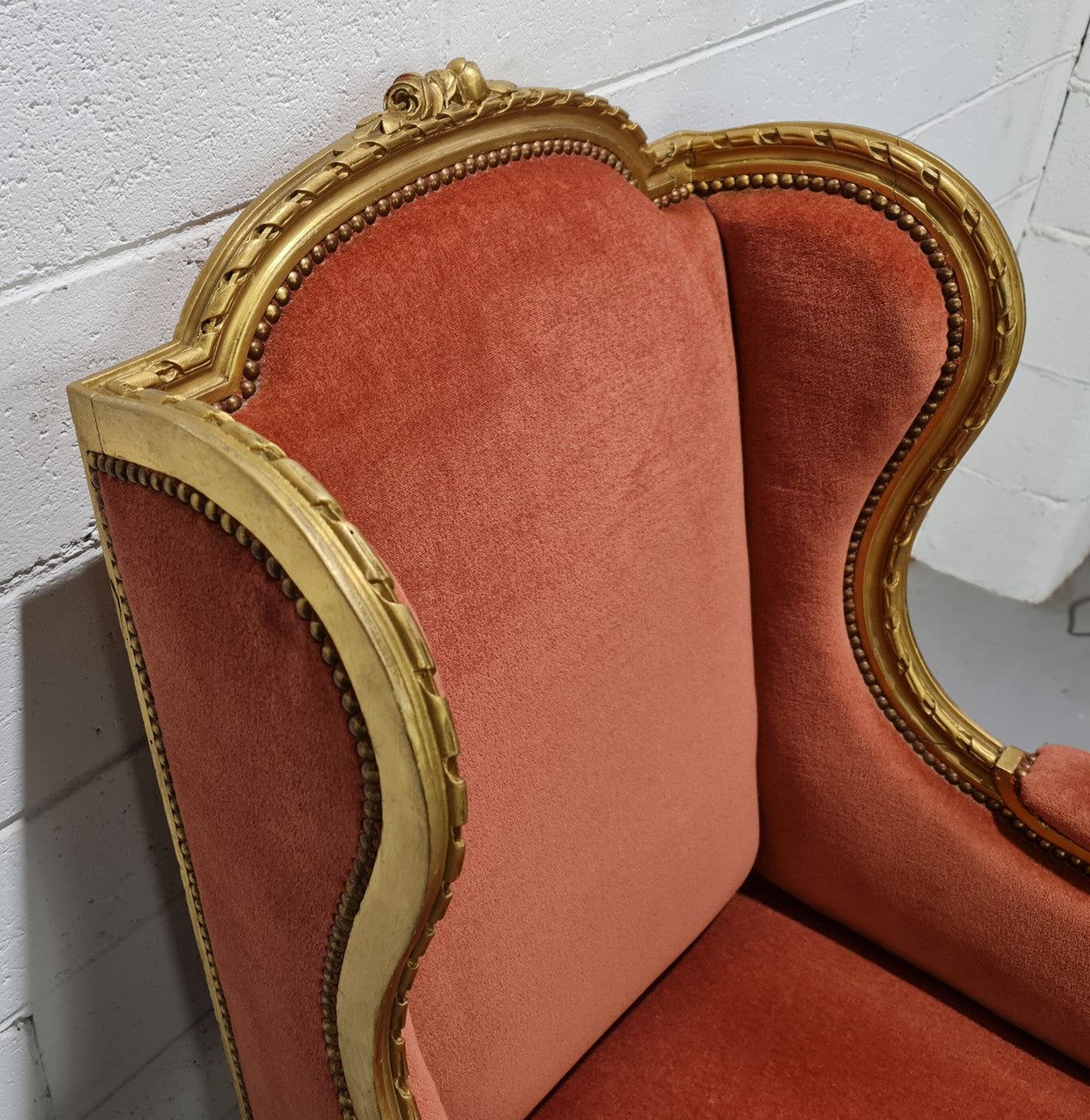 Antique Louis XVI style gilt upholstered bergere wingback chair. The fabric is in good used condition and the chair is very comfortable to sit in.