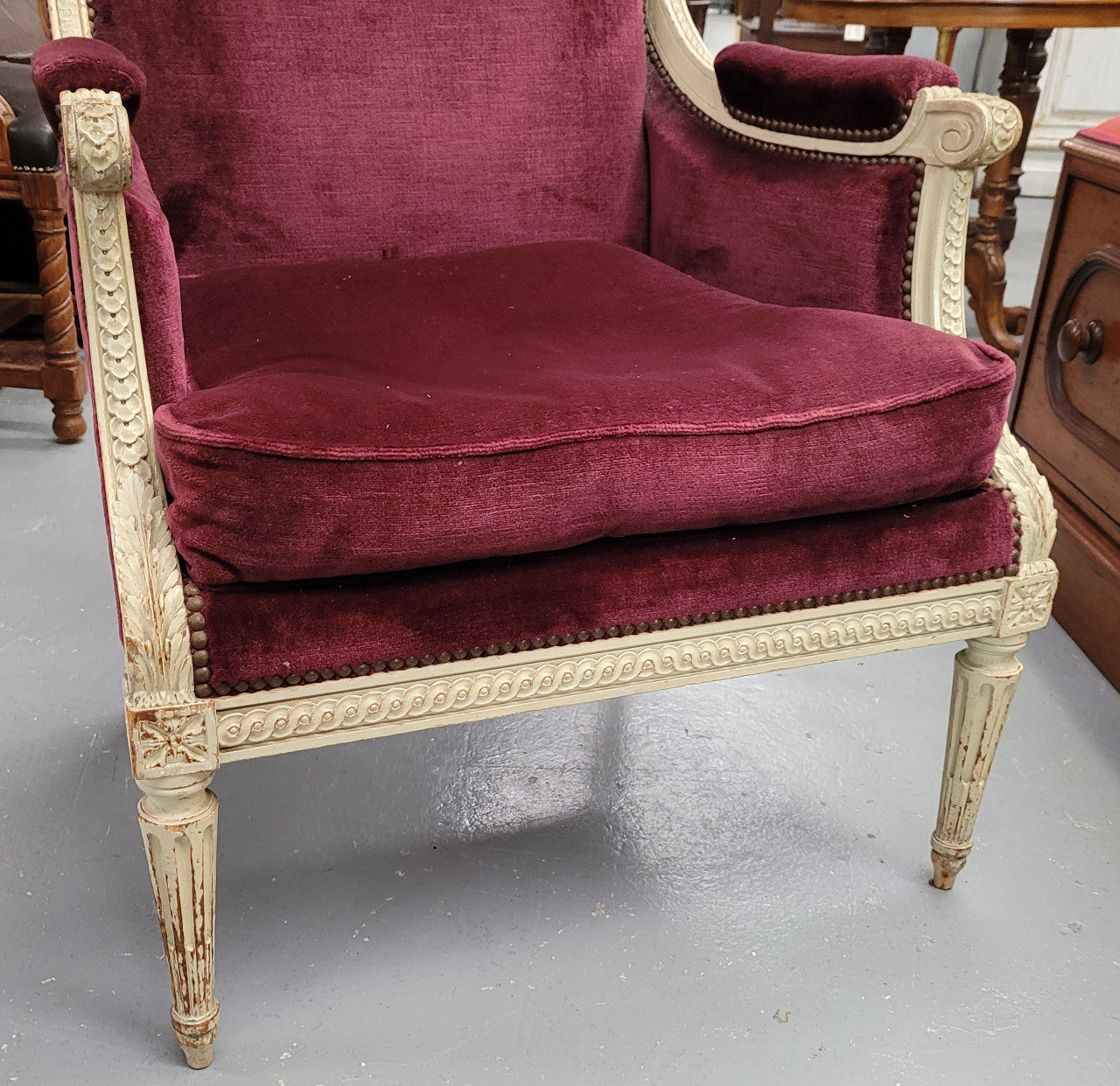 Louis 16th Style high back upholstered chair with maroon velvet fabric, decorative carvings and original paint. It has been sourced from France and in good original condition.