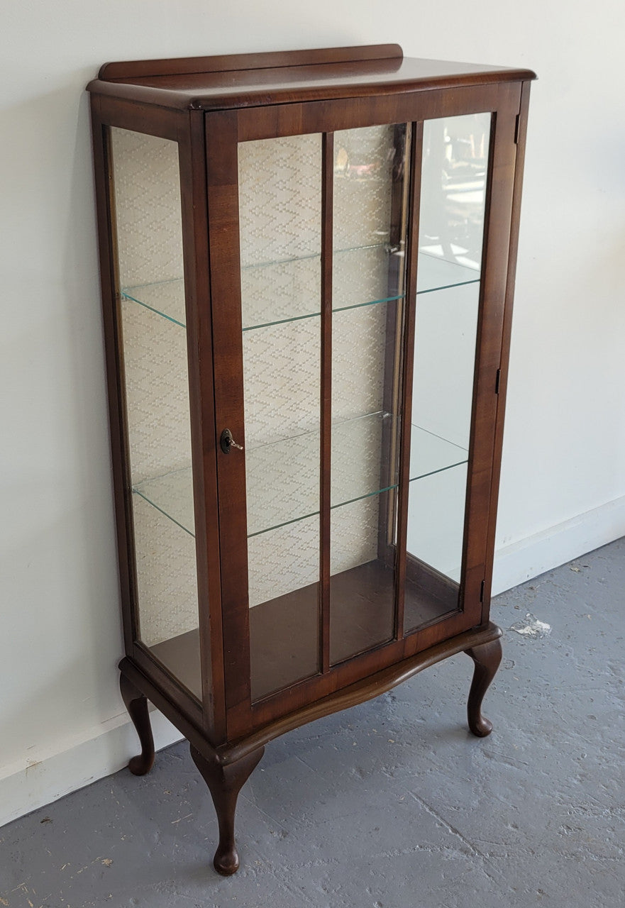 Petite single door Walnut display cabinet. Art Deco style with glass display door and two fixed shelves. In original condition.