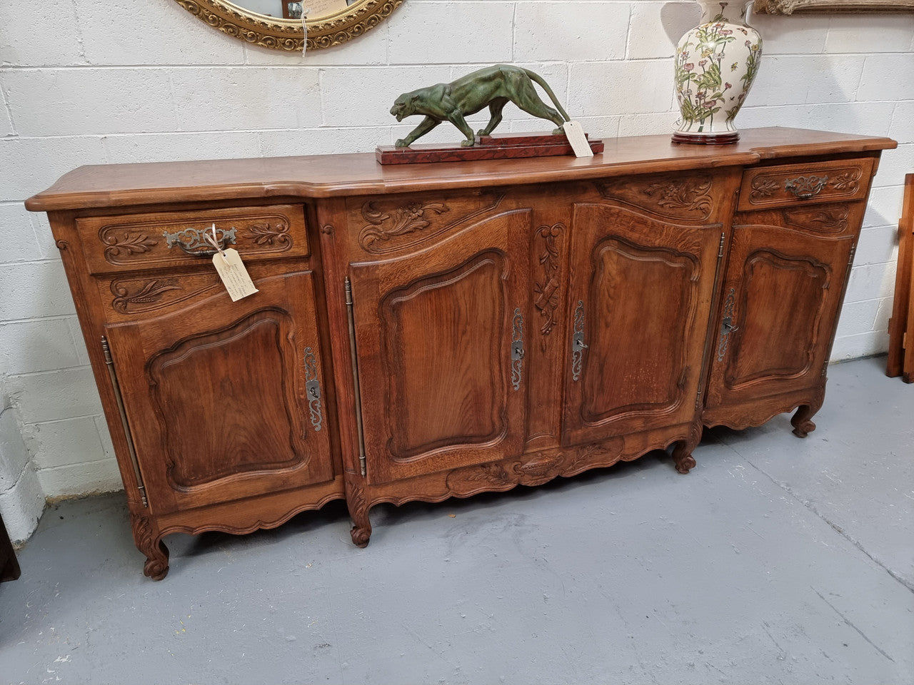 Parquetry top French oak Louis XV style sideboard with two draws and four cupboards. In good original detailed condition.