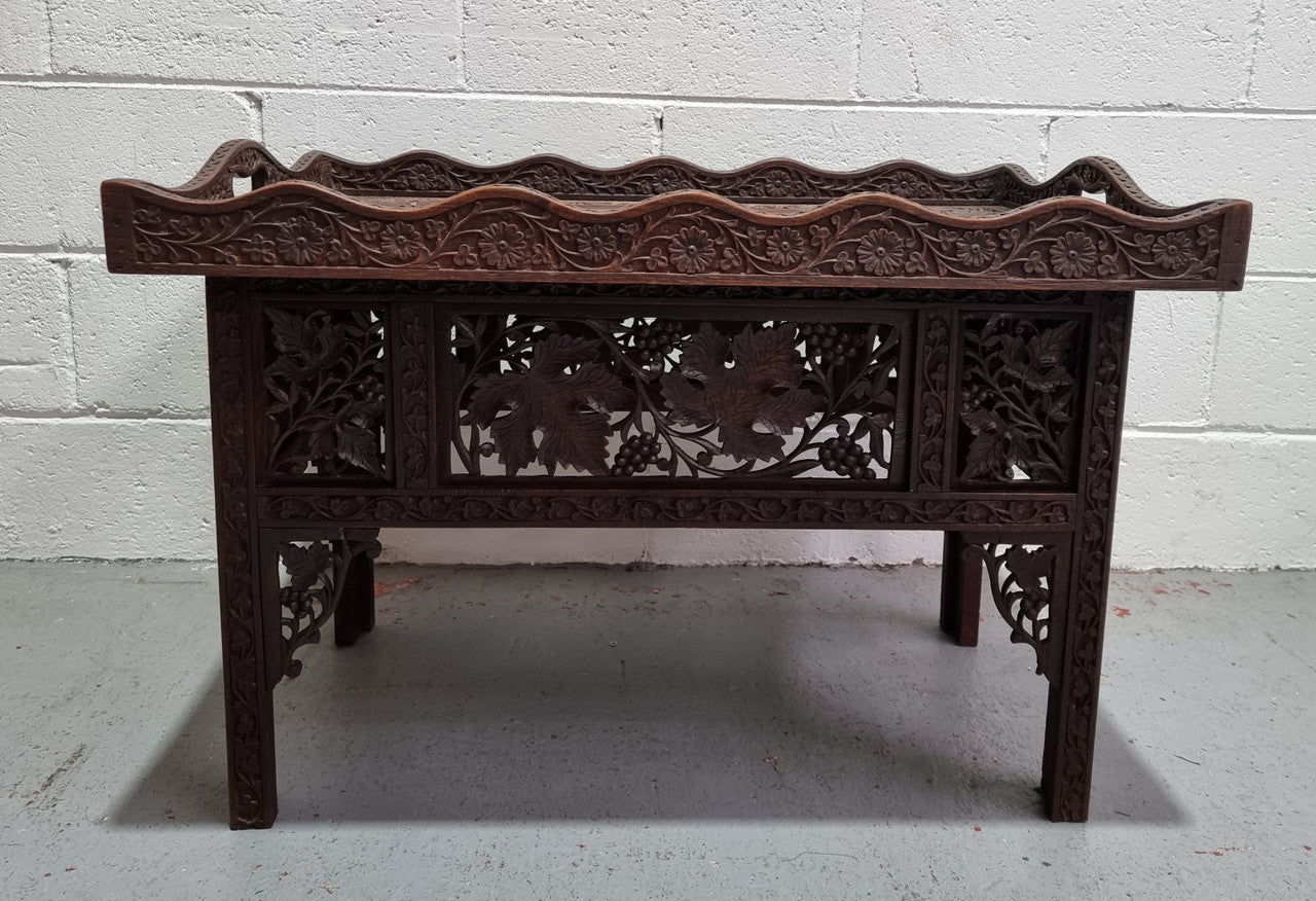 Anglo Indian folding occasional table with lift-up tray top. The tray has brass inlay and ornate carvings. The bottom of the table folds down and it is in good original condition.