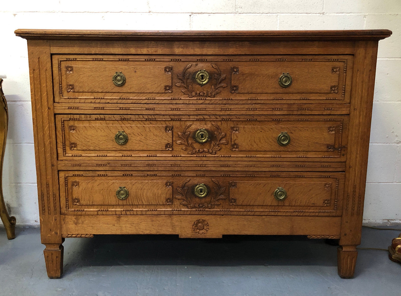 Lovely carved early 19th Century French Oak commode. There are three drawers with decorative drawer pulls and is in good original detailed condition.