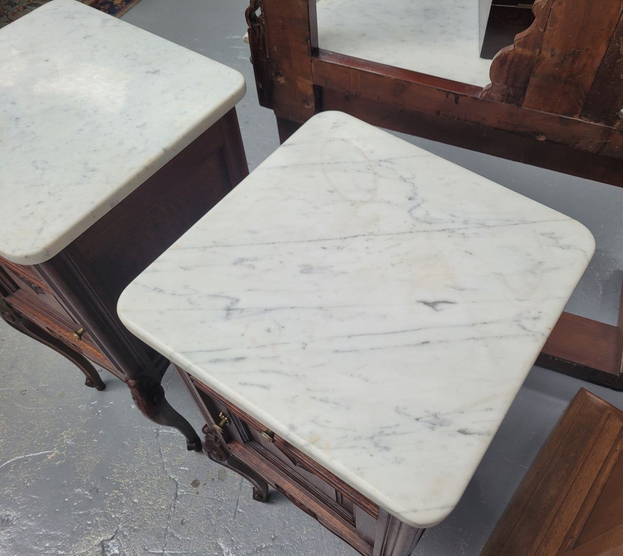 Pair French oak Louis XV style white carrera marble top bedside cabinets. Consisting of one drawer and one cupboard each on elegant legs. Circa: 1900's
