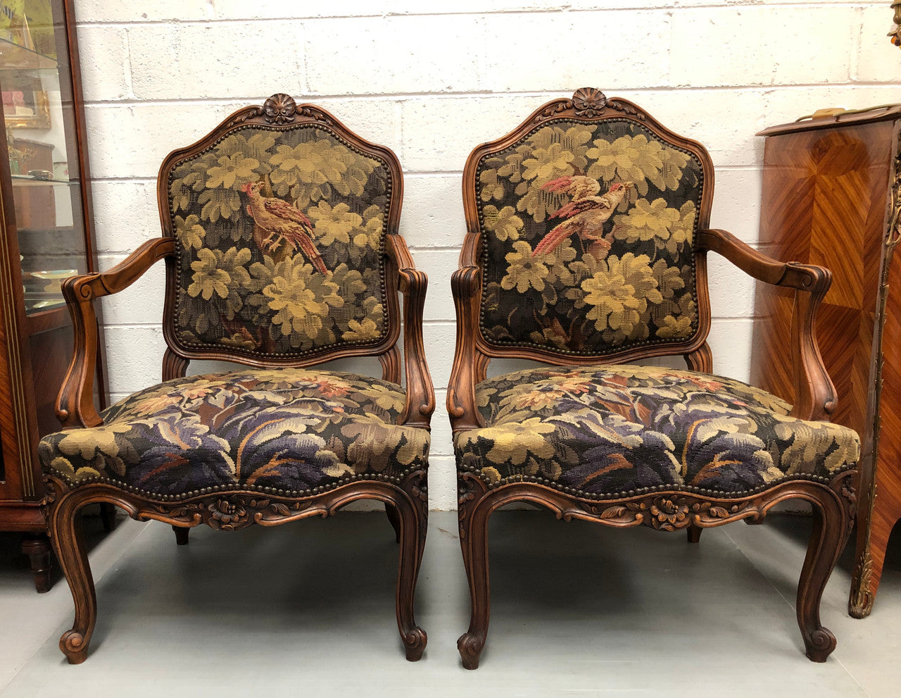 Pair of 19th Century French walnut tapestry covered arm chairs. They are in good original condition. Circa 1890.
