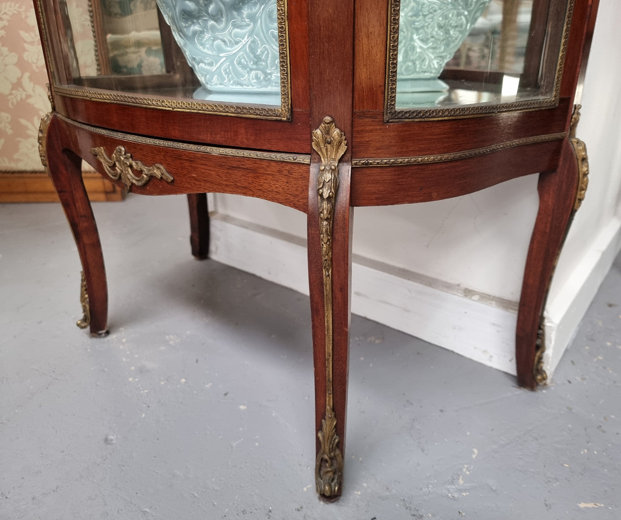 Beautiful French Louis XV style vitrine/ display cabinet with curved glass, gilt mounts, mirrored back and two glass shelves for your displays . It is in good original detailed condition.