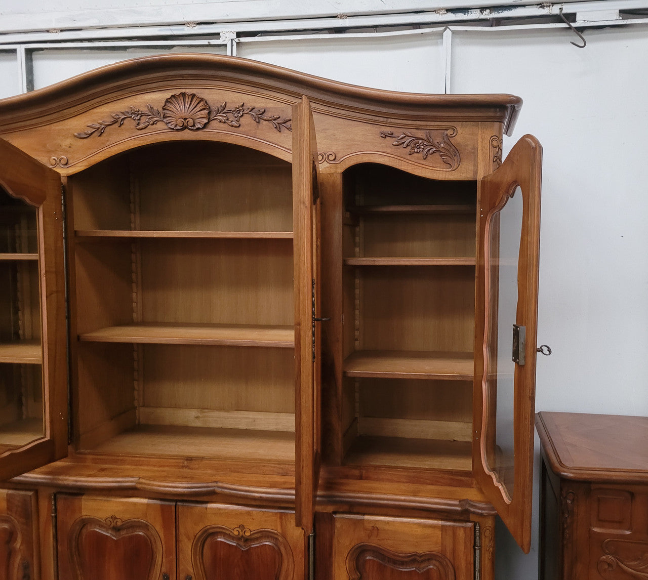 Magnificent French Walnut two-body four door display cabinet. Heaps of storage space with four glass doors at the top with shelves and four solid doors below also with shelving. It has been sourced from France and comes with a key for each door and all are lockable. In good original detailed condition.