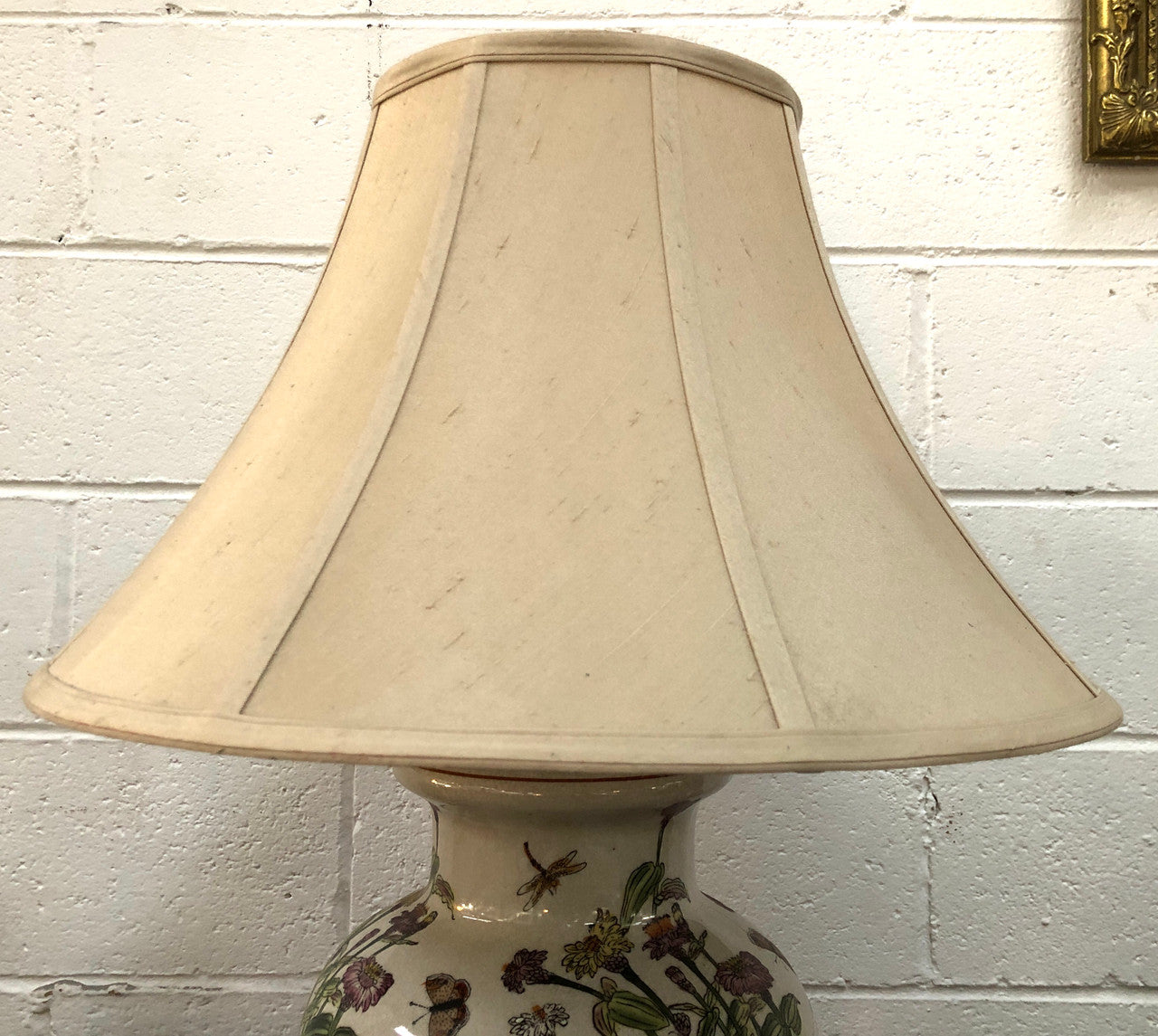 Contemporary ceramic lamp base decorated with daises & butterflies on a wooden base with shade.