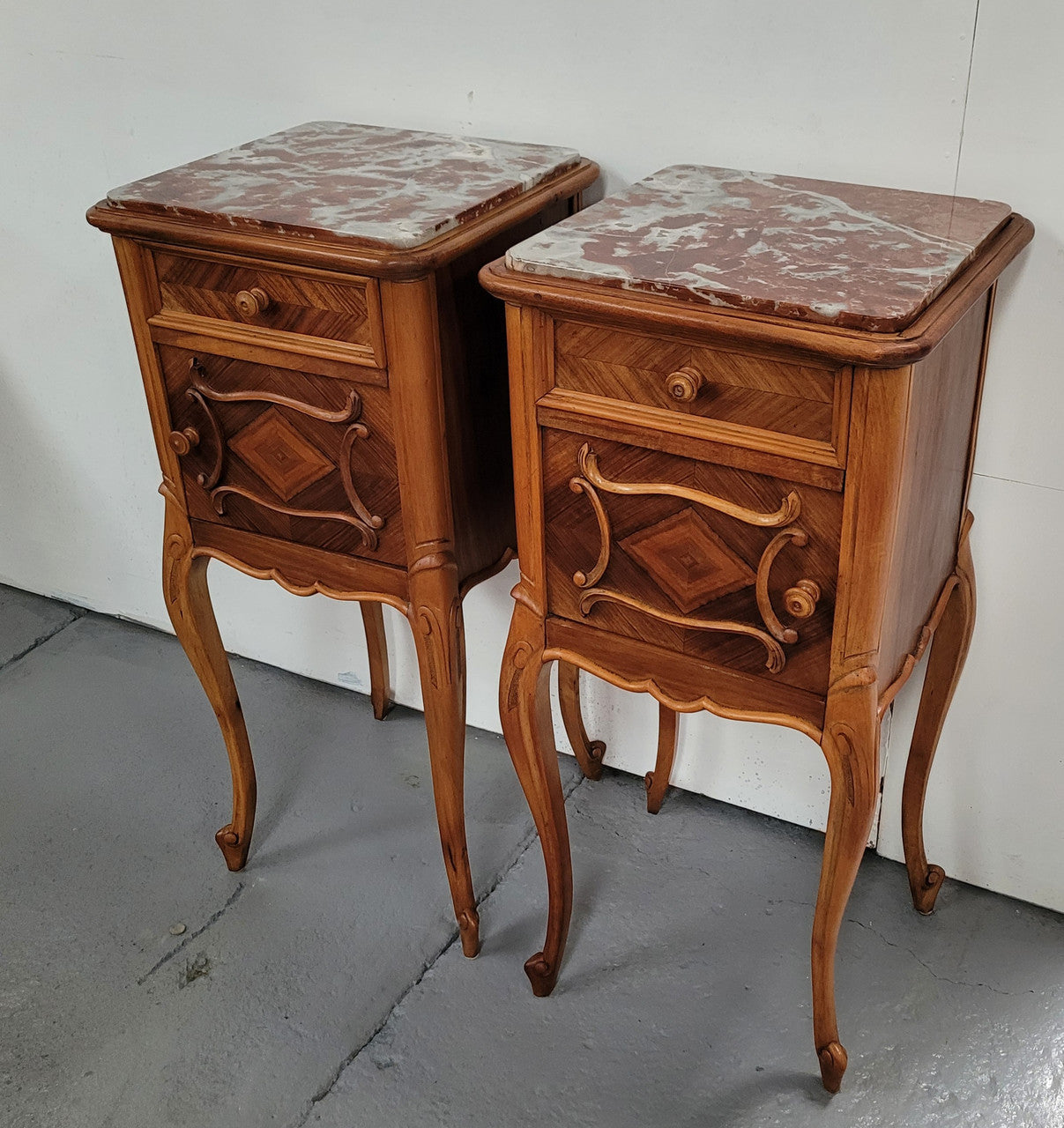 Pair French Walnut Louis XV style Bedside Cabinets with inset rouge carrera marble tops and parquetry inlay. Consisting of one drawer and one cupboard on very elegant legs. Circa: 1900's.